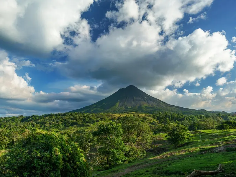 De kegelvormige Arenal-vulkaan boven het groene heuvellandschap rond La Fortuna